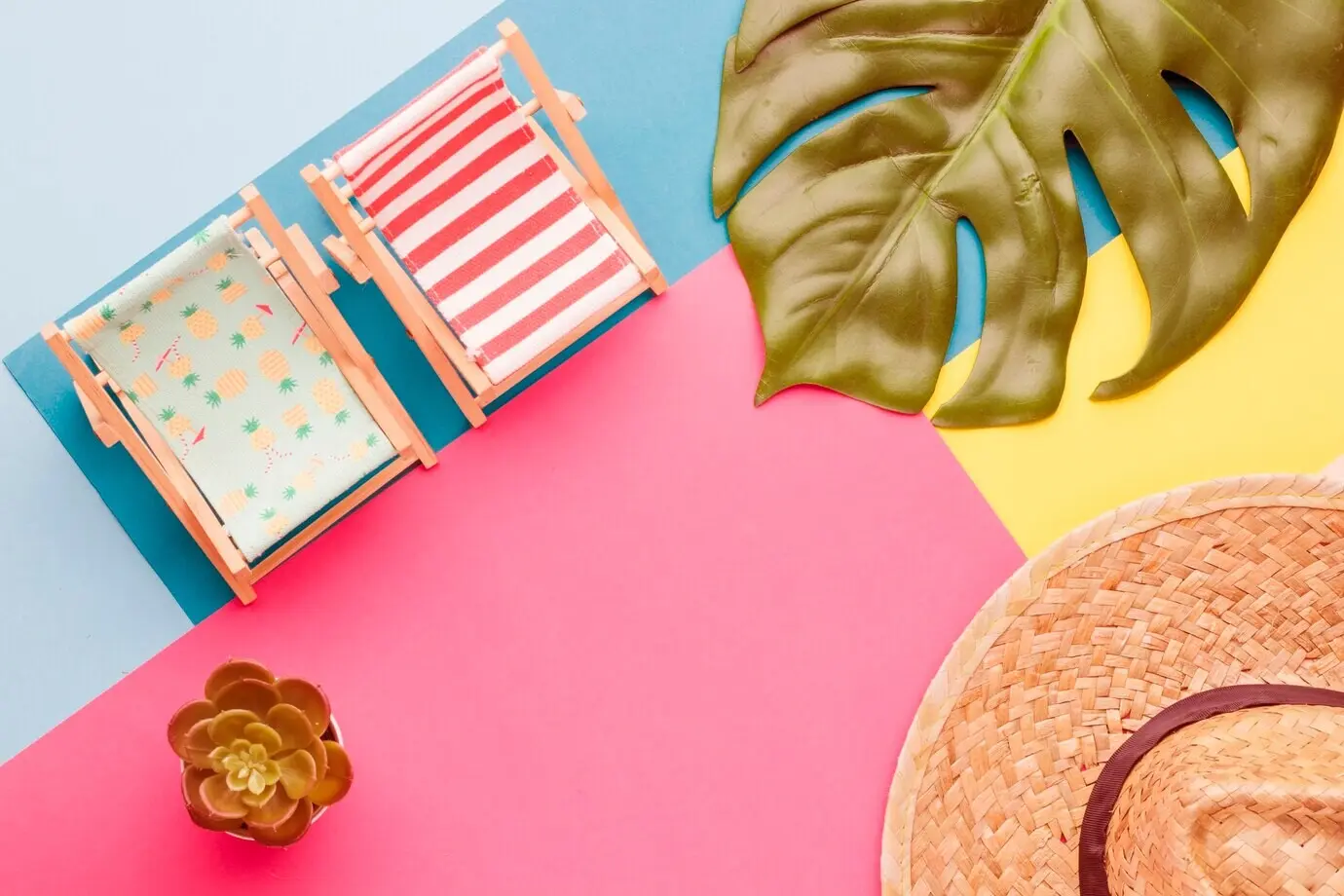 Arrangement aus Liegestühlen, einem Hut und Pflanzen